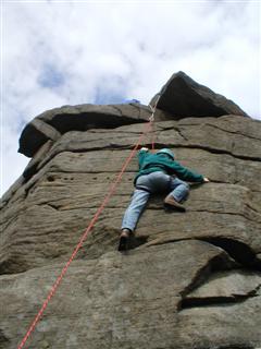 Climber on rock-face supported by a rope above, to illustrate how the KSA can support those with KS as they work toward their potential